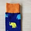 blue sock with blue and yellow elephants on them . close up image