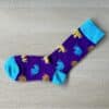 purple sock with blue and yellow elephants on them pointing left