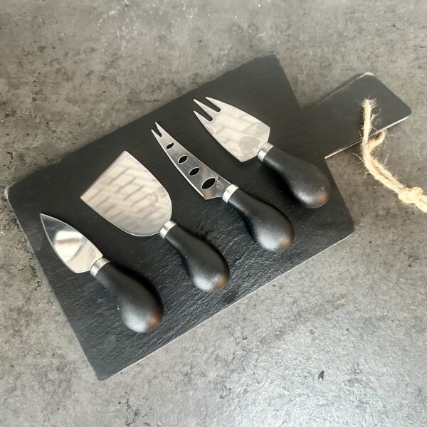 slate cheese board with knives and a block of cheese