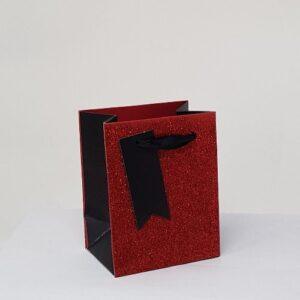Red glitter perfume gift bag with black sides and ribbon handle.