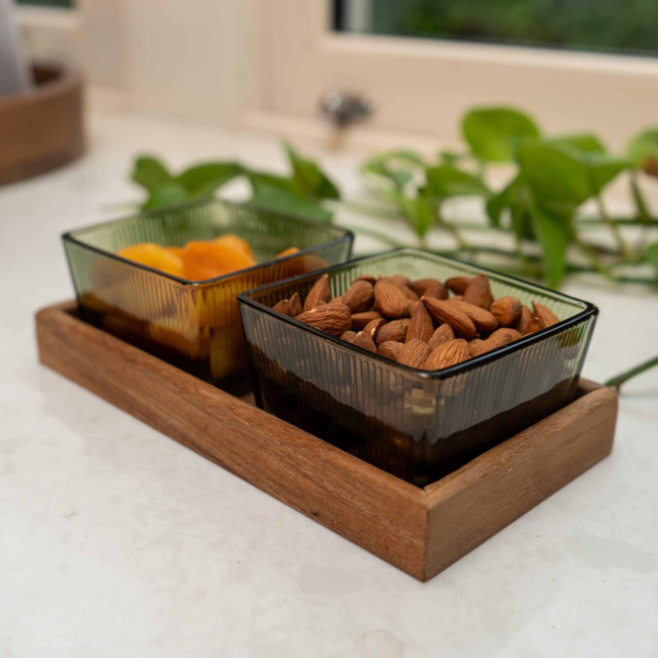set of 2 green glass serving bowls on acacia wooden tray